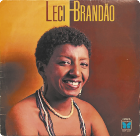 Capa de álbum com fotografia de Leci Brandão. Ela é uma mulher sorridente com cabelos curtos e cacheados, usando brincos e colares.