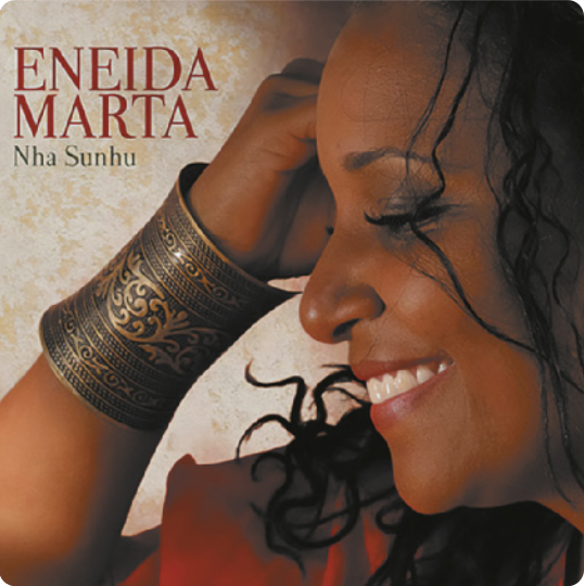 Capa de álbum com fotografia de Eneida Marta. Ela está de perfil, sorrindo, com os cabelos cacheados e um bracelete de metal ricamente ornamentado no pulso.