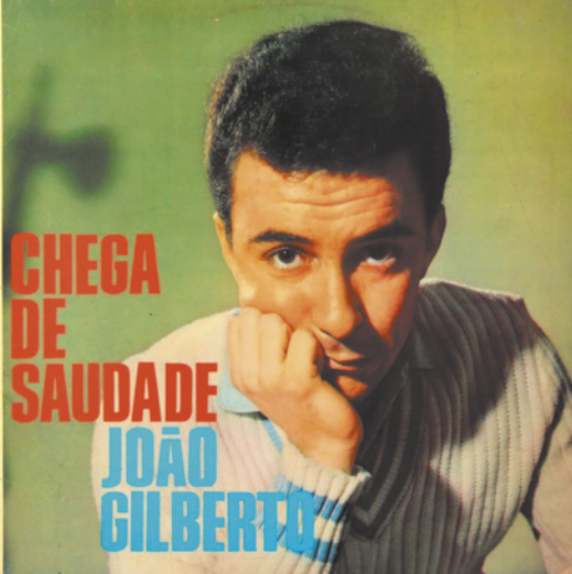 Capa de álbum com fotografia de João Gilberto. Ele é um homem de cabelos curtos, usando um suéter, com o lado direito do rosto apoiado na mão direita.