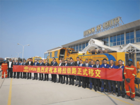 Fotografia de muitos homens enfileirados segurando uma longa faixa escrita em chinês.
