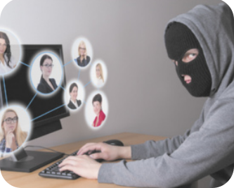 Imagem de pessoa com capuz e balaclava em frente a um computador.