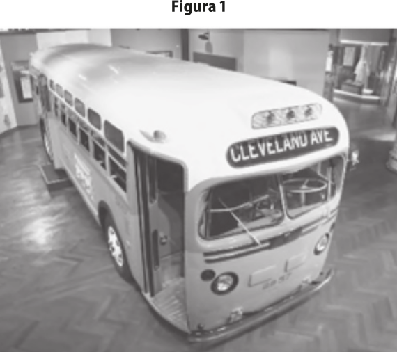 Fotografia em preto e branco de ônibus antigo em museu. No letreiro do ônibus está escrito 'Cleveland ave'.