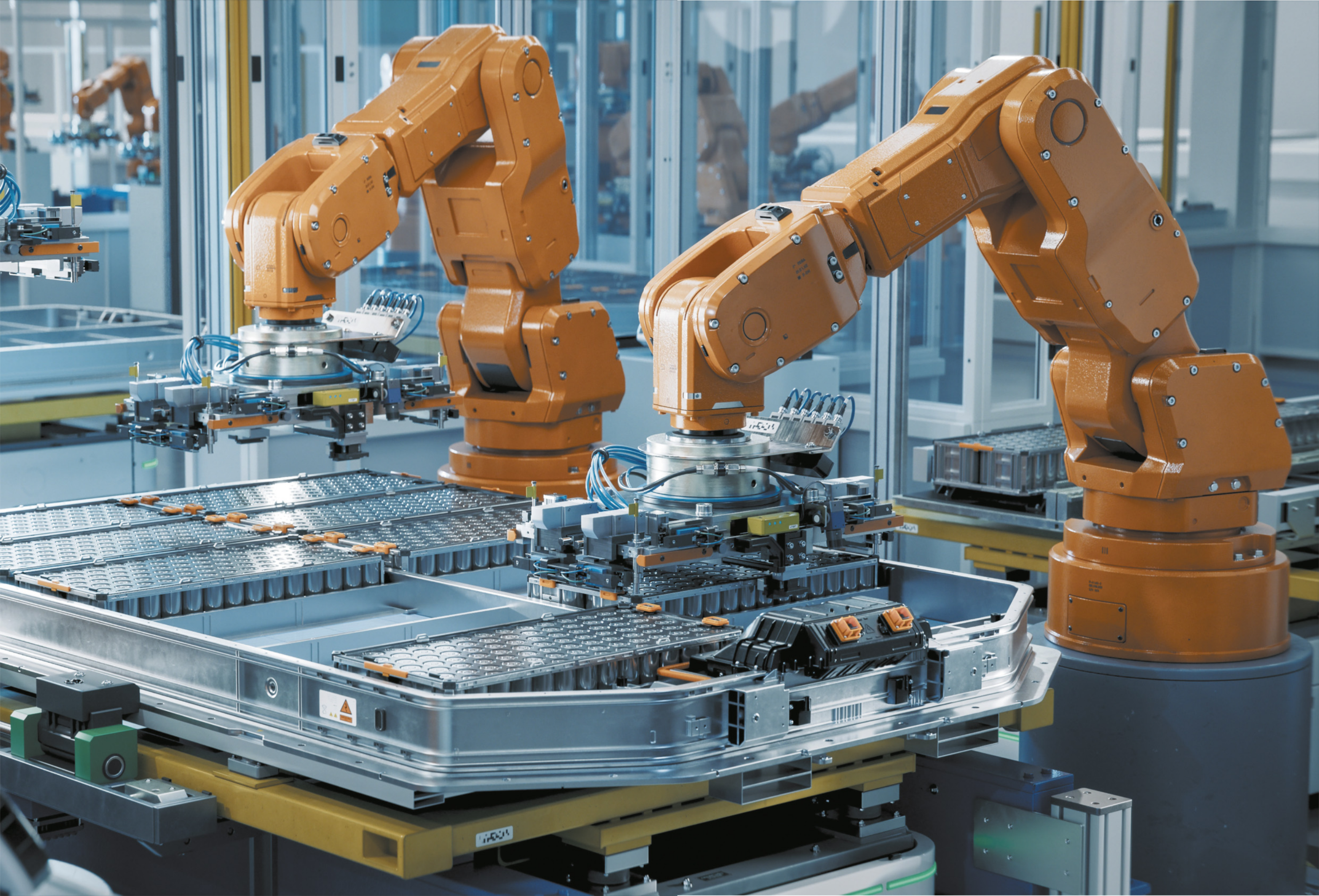 Fotografia de máquinas robotizadas montando peças em uma fábrica.