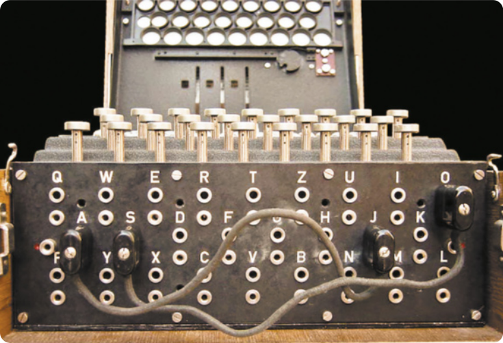 Imagem da máquina criptográfica Enigma. A máquina é uma caixa que possui letras na parte da frente e botões na parte superior.