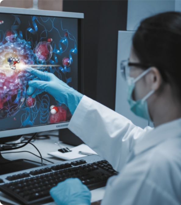 Fotografia de mulher cientista apontando para tela de computador. Ela usa óculos de proteção, máscara de proteção, jaleco e luvas.