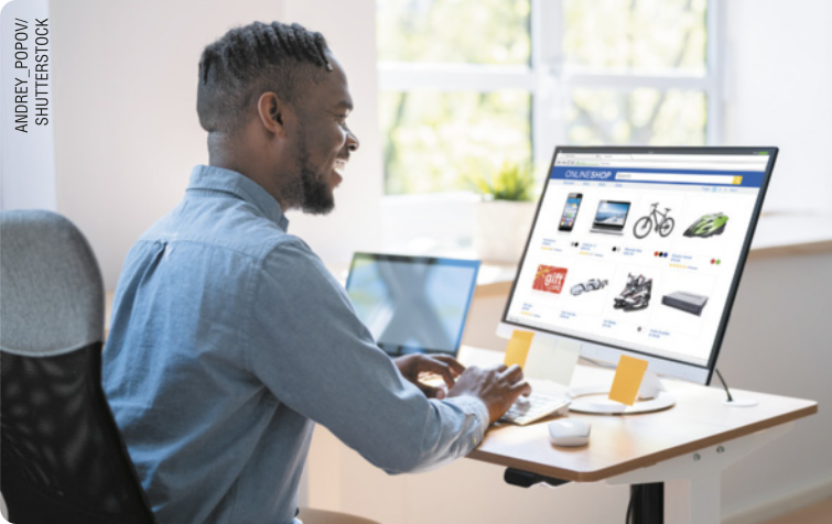Fotografia de homem em frente a computador que mostra produtos para compra on-line.