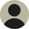 Ícone representando um perfil de uma pessoa em uma rede social. O ícone é composto por um fundo circular com a silhueta de uma pessoa representando a cabeça e os ombros.