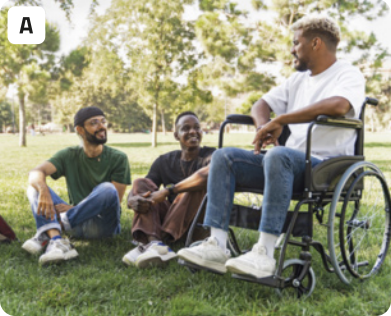 A. Fotografia de três jovens conversando em um parque. Dois jovens estão sentados na grama com os cotovelos apoiados nos joelhos, olhando para um terceiro, que está usando cadeira de rodas. Os jovens estão com a expressão alegre. Ao fundo, há muitas árvores.