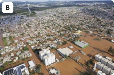 B. Fotografia aérea de uma cidade completamente inundada. As ruas estão tomadas por uma água de cor marrom, e apenas os topos de prédios e casas estão visíveis.