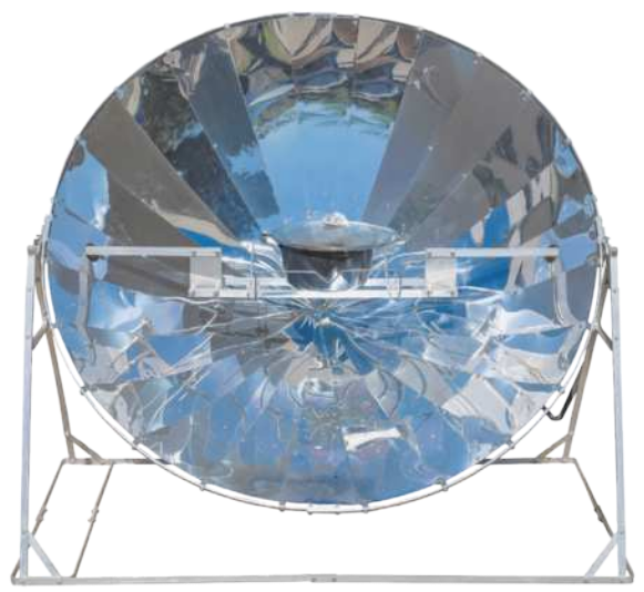 Fotografia de um forno solar. Aparelho de metal, com uma superfície redonda, curvada, refletora da luz solar. O aparelho está apoiado em uma base de metal, com suporte e um recipiente, redondo no meio do suporte.