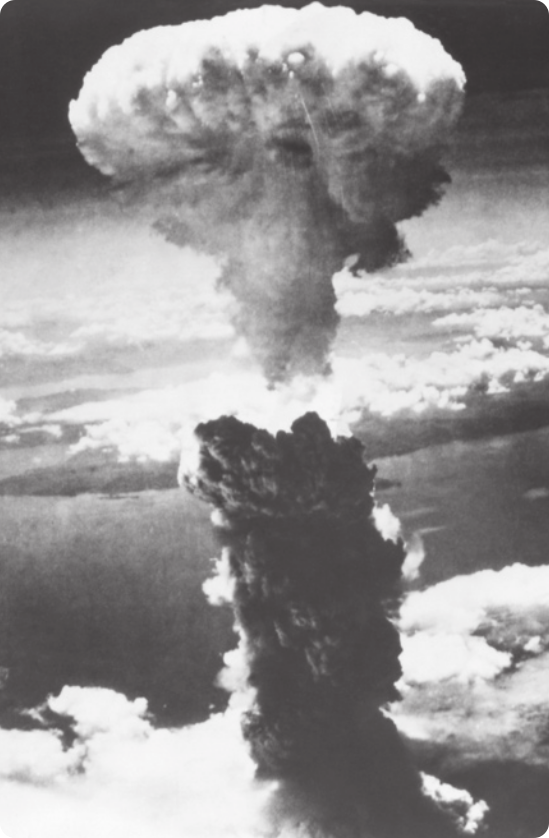 Fotografia em preto e branco da explosão da bomba atômica em Nagasaki. Há uma grande quantidade de fumaça formando uma nuvem no céu.