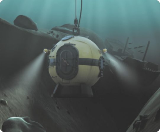 Fotografia de um submarino em formato de esfera, preso por um cabo. Ele está no fundo do mar, com os faróis acesos.