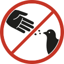 Imagem de uma placa em formato circular, com borda vermelha e fundo branco. No centro, há o desenho de uma mão estendida com pequenos pontos caindo em direção a um pássaro. Uma faixa diagonal vermelha atravessa a imagem.