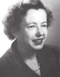 Fotografia em preto e branco de Maria Goeppert sorrindo. Ela é branca, tem os cabelos pretos, curtos e ondulados, e está usando paletó feminino e colar.