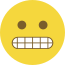 Emoji formado por um círculo amarelo, com olhos pretos e dentes cerrados.