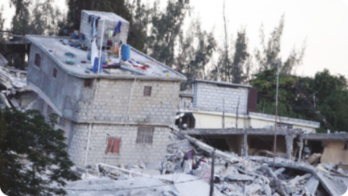 Fotografia de área urbana com casas inclinadas e destroços.