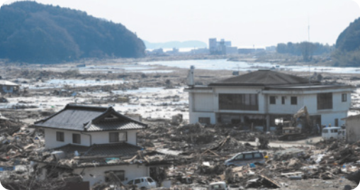 Fotografia de duas casas em meio a muitos destroços.