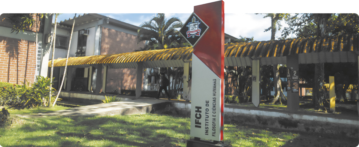 Fotografia da entrada de um prédio. Há um painel vertical com o texto: 'I F C H; Instituto de Filosofia de Ciências Humanas'.