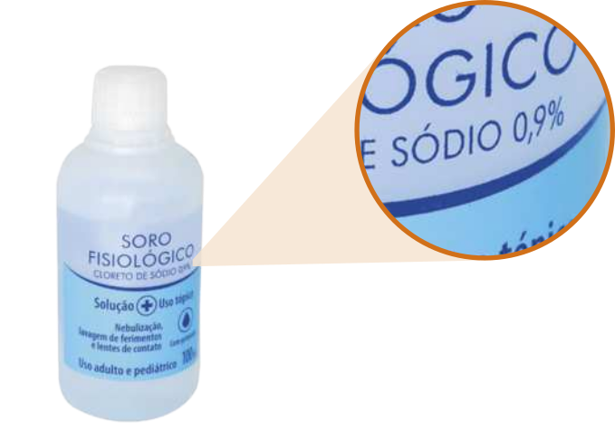 Imagem de um frasco de soro fisiológico com uma ampliação indicando o texto 'sódio 0,9 por cento'.