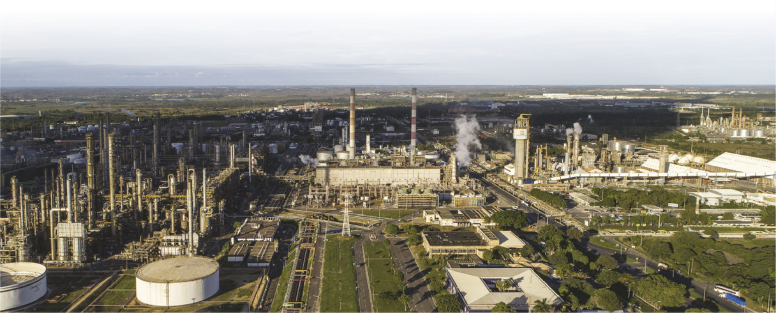 Fotografia com vista de cima de área industrial com várias refinarias.