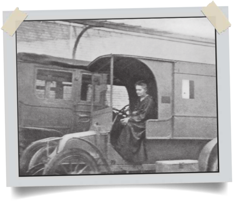 Fotografia de Marie Curie sentada diante do volante de um automóvel grande.