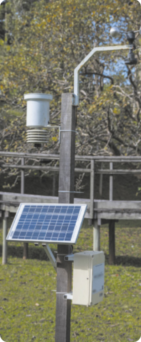 Fotografia de equipamentos fixados em um poste. Há também um painel solar.