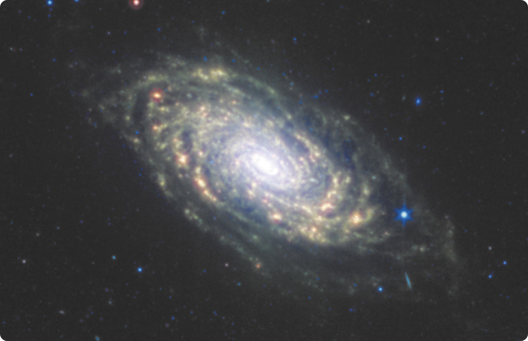 Imagem de uma galáxia. Ela é formada por um centro iluminado rodeado por diversos pontos ao redor formando uma espiral.