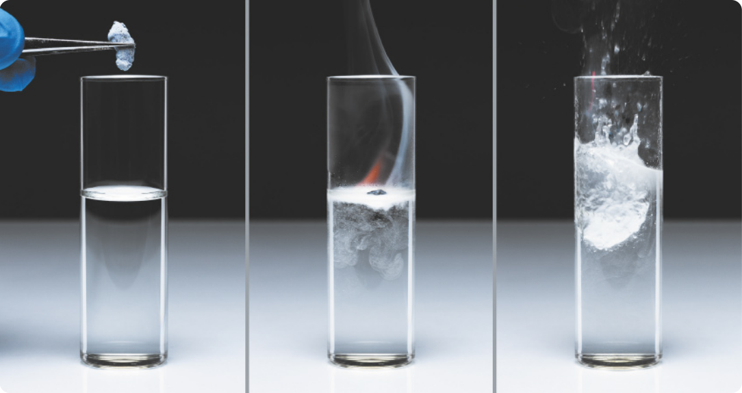 Fotografia de três momentos de um experimento. No primeiro momento, há um tubo com água e uma pinça segura um pedaço de potássio sobre sua abertura. No segundo, o potássio está flutuando; há chama e fumaça na superfície da água. No terceiro momento, a água está borbulhando e respingando para fora do tubo.