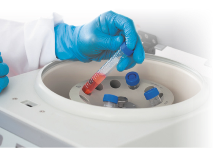 Fotografia de tubos de ensaio em um equipamento de laboratório. Eles estão posicionados em uma estrutura circular.