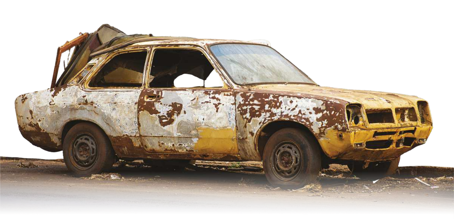 Fotografia de um carro velho, bastante enferrujado.