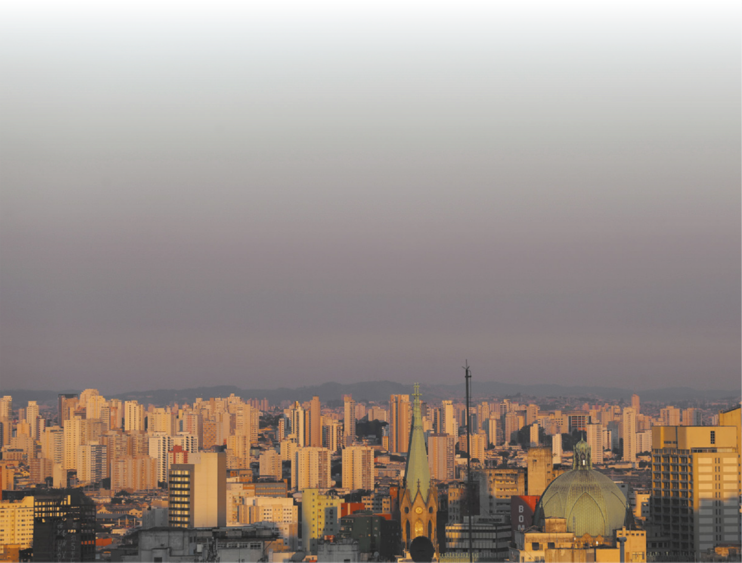 Fotografia de grande ambiente urbano. Sobre ele, na atmosfera, uma camada turva e acinzentada.