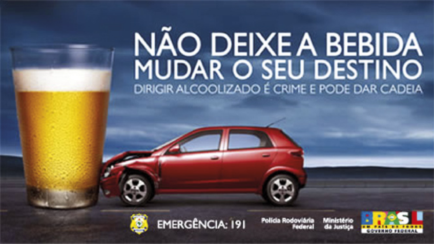 Cartaz de campanha publicitária com imagem de um carro com a parte dianteira colidindo com um copo de cerveja desproporcionalmente grande, em uma estrada com o céu nublado ao fundo. O texto no cartaz diz: 'Não deixe a bebida mudar seu destino. Dirigir alcoolizado é crime e pode dar cadeia. Emergência: 191'. No canto inferior direito há logotipos da Polícia Rodoviária Federal, do Ministério da Justiça e do Governo Federal.