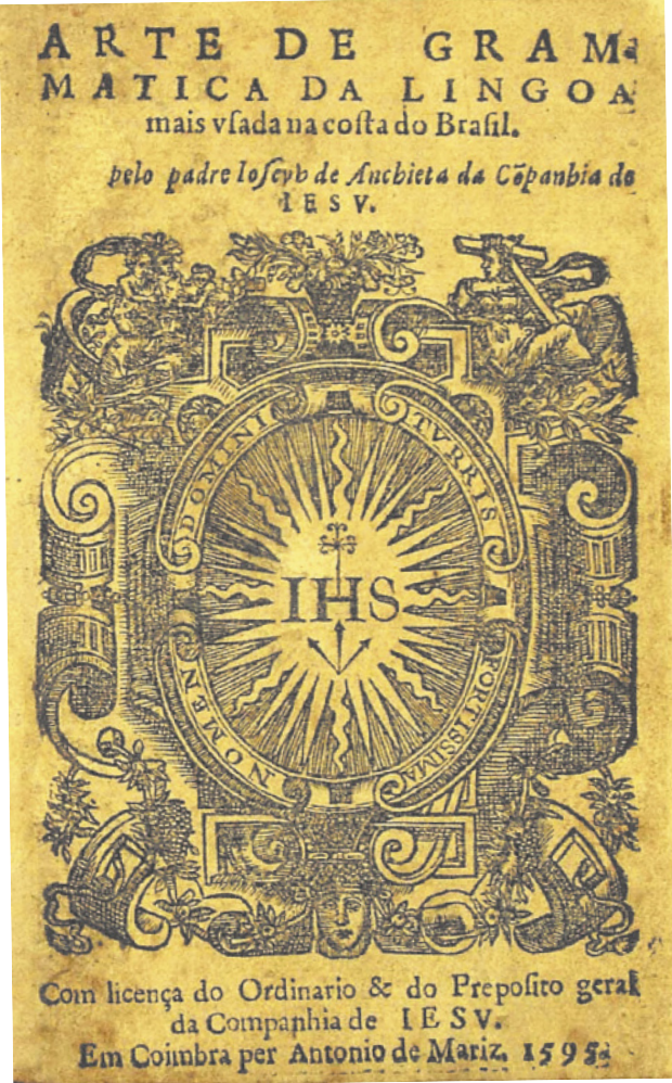 Capa de livro com gravura de um brasão jesuíta, com formas barrocas, palavras em latim e figuras religiosas. O texto na capa está escrito em português arcaico e diz o seguinte: 'Arte de gramática da língua mais usada na costa do Brasil. Pelo José de Anchieta da Companhia de Jesus. Com licença do Ordinário e do Prepósito geral da Companhia de Jesus. Em Coimbra por Antonio de Mariz, 1595.'