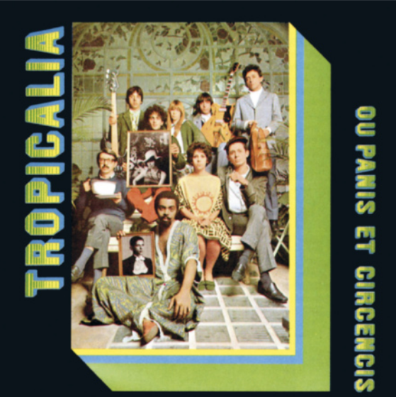 Capa de álbum com fotografia de diversos músicos reunidos, posando para a fotografia. Alguns deles usam roupas coloridas e outros usam jaquetas de couro. Caetano Veloso e Gilberto Gil estão segurando quadros com retratos de pessoas em preto e branco; e dois integrantes do grupo Os Mutantes seguram um contrabaixo e uma guitarra elétrica. Ao fundo, há uma imagem de uma grande janela com formas rebuscadas, dando vista para uma paisagem com plantas e árvores. A fotografia está enquadrada por faixas das cores da bandeira nacional, que também estão presentes na tipografia do título do álbum.