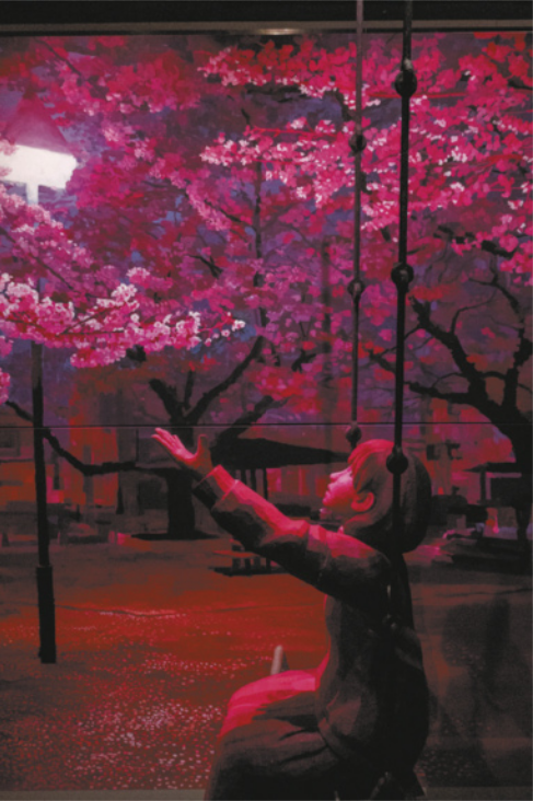 Pintura representando uma paisagem urbana à noite, com a escultura de uma garota ajoelhada no chão, com os braços para o alto em direção às flores de cerejeiras na paisagem ao fundo. Toda a pintura e a iluminação da escultura da garota têm as luzes representadas em um espectro de cores entre o vermelho e o magenta.