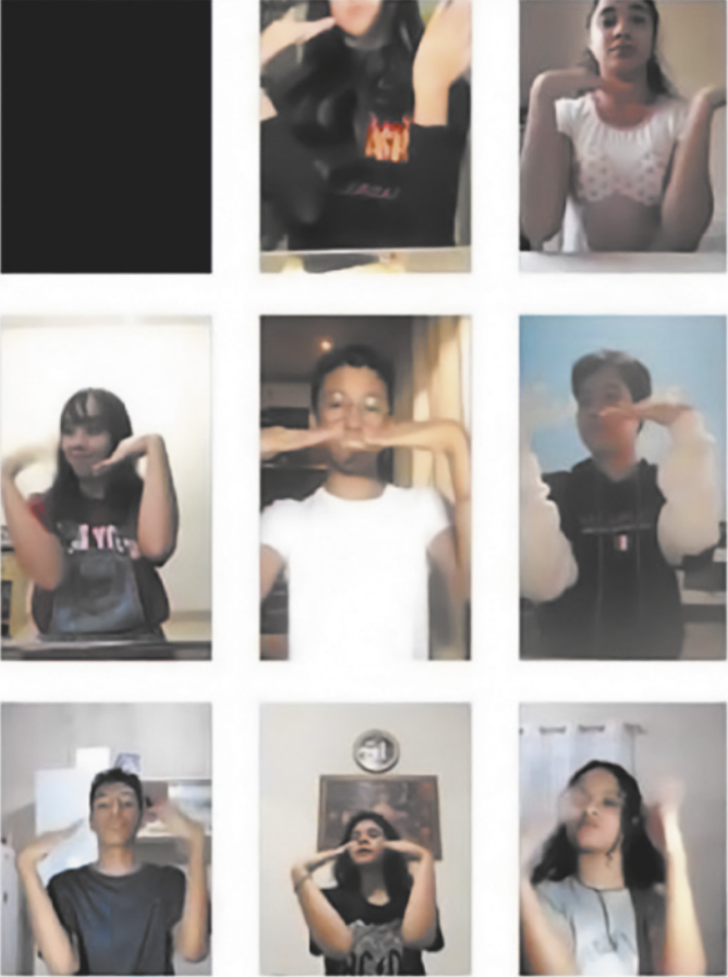 Imagem composta de 9 fotografias de jovens com as mãos diante do rosto, estendidas na horizontal, realizando um movimento coreografado. Cada jovem está em um local diferente, e alguns deles estão sentados diante de mesas, à frente de computadores ou smartphones cujas câmeras registram a dança de cada integrante do grupo isoladamente, a partir de suas casas. Uma das fotografias mostra uma tela escura, relacionada a alguma falha de transmissão ou ausência de um dos integrantes.