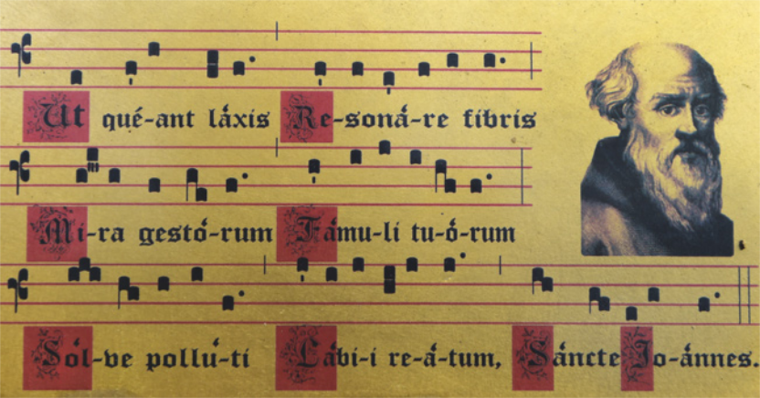 Reprodução de partitura com pautas de quatro linhas horizontais paralelas. A notação é semelhante à das partituras atuais, porém os formatos das notas são diferentes. A letra da melodia acompanha a partitura, escrita em caligrafia ornamental e rebuscada, em latim. Ao lado da partitura há uma gravura com o retrato de um homem calvo, com a barba longa e grisalha.