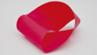 Fotografia de uma fita de Möbius feita com papel, com a forma de uma faixa torcida, cujas extremidades estão ligadas.