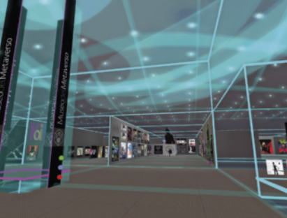 Imagem de um espaço interior com estética de realidade virtual. Há algumas luzes azuladas e linhas de grade que definem o espaço. As paredes, o chão e o teto são em tons de cinza. Há uma placa vertical escrito 'Metaverso'.