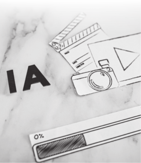 Imagem em preto e branco com elementos desenhados em papel representando ícones relacionados à produção audiovisual, como uma claquete, uma câmera fotográfica, uma janela de vídeo com símbolo de play e uma barra de carregamento marcando 0%, posicionados sobre uma superfície marmorizada, ao lado das letras recortadas 'IA'.