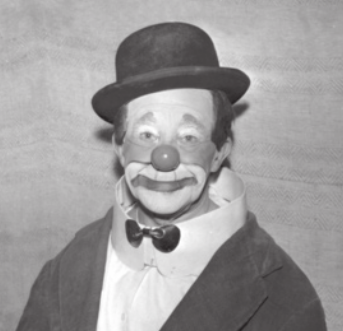 Fotografia em preto e branco de Piolin. Ele é um homem com o rosto pintado como palhaço, usando um chapéu e uma gravata borboleta.