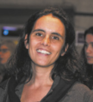 Fotografia de Renata Meirelles. Ela é uma mulher sorridente, de cabelos longos.