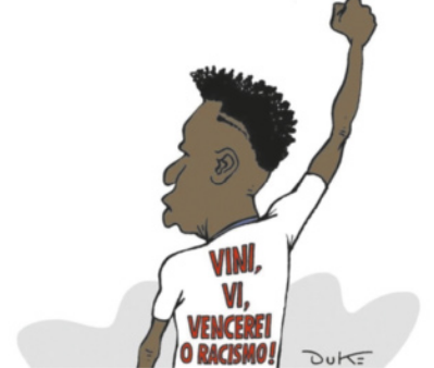 Charge com a figura do jogador de futebol Vinicius Júnior de costas com o braço erguido para o alto, com o punho fechado. Na camiseta dele há a mensagem 'Vini, vi, vencerei o racismo!'