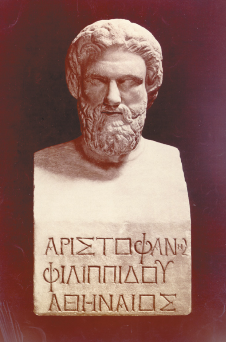 Imagem do busto de Aristófanes. Ele possui barba e cabelos ondulados e está com inscrições gregas na altura do peito.