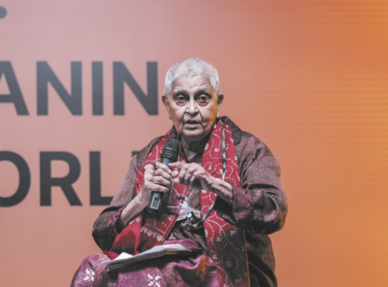 Fotografia de Gayatri Chakravorty Spivak. Ela é idosa, possui cabelos brancos curtos, está sentada e utiliza um microfone.