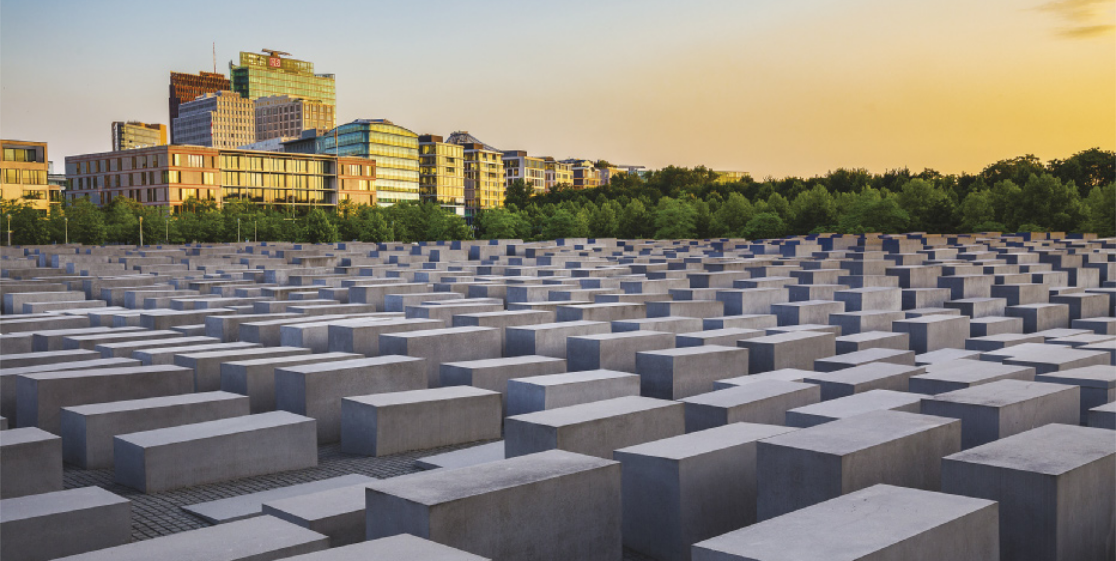 Imagem de memorial composto por diversos blocos retangulares. Eles possuem alturas diferentes e estão enfileirados em uma área plana.