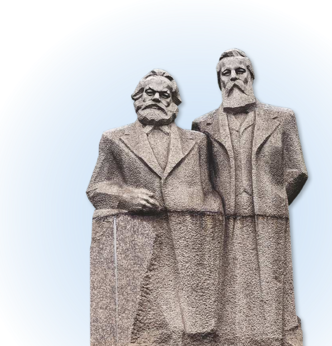 Imagem de escultura que representa a Karl Marx e Friedrich Engels. Marx, à esquerda, possui cabelos, bigode e barba abundantes. Engels, à direita, é mais alto, mais magro e possui cabelo curto, bigode e barba longa. Ambos usam sobretudo.