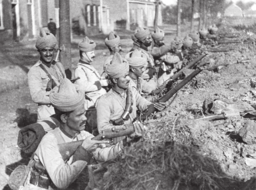 Imagem em preto e branco de soldados. Eles estão em uma trincheira, atirando com rifles.