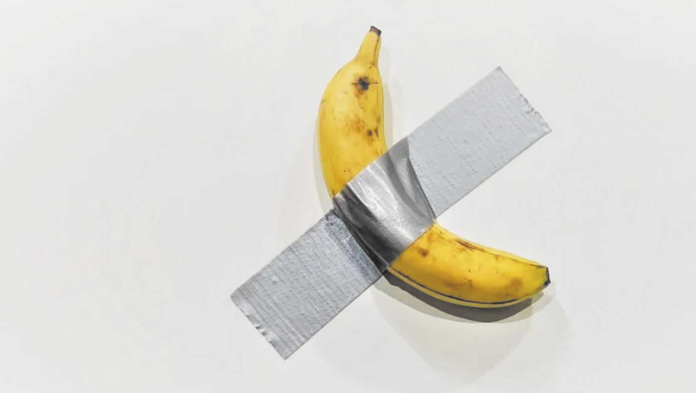 Imagem de banana madura grudada em uma superfície com fita adesiva.