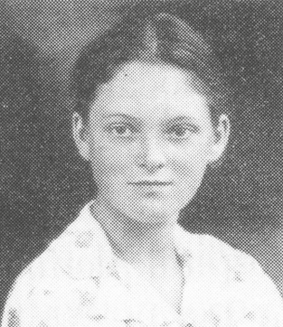 Fotografia em preto e branco de busto de uma mulher jovem com cabelo preso, usando uma camisa clara.